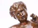 a bronze statue of a boy with a fist in his hand