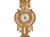 une horloge dorée accrochée au mur, sur laquelle se trouve une horloge