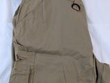 men ' s khaki pants on a bed with a tag on it