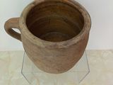 a brown cup that is sitting on a clear stand