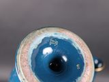 a blue vase with a gold rim sitting on a table