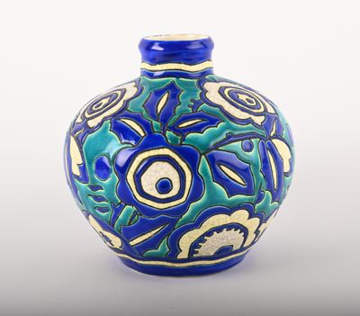 un vase bleu et vert posé sur une surface blanche