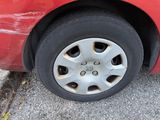 a red car that has a flat tire on it