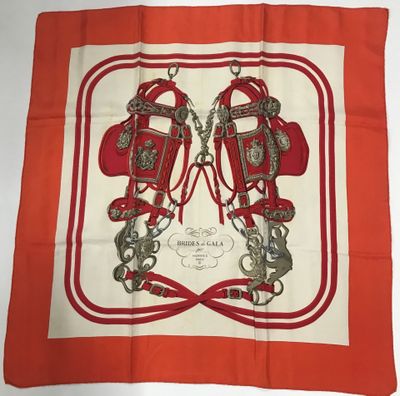 un gros plan sur une écharpe rouge et blanche sur laquelle est représentée une paire de chaussures