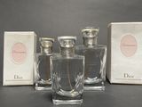 three bottles of perfume sitting on a table next to a box