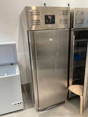 two stainless steel refrigerators next to each other in a room