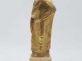 a gold statue of a man in a robe on a marble base