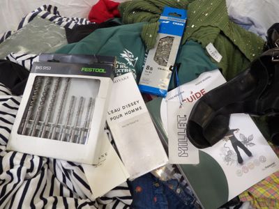 a pile of clothing and a pair of shoes on a bed
