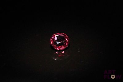 a close up of a pink diamond on a black surface