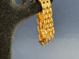 un bracelet en or suspendu à un arbre, avec un ciel bleu en arrière-plan