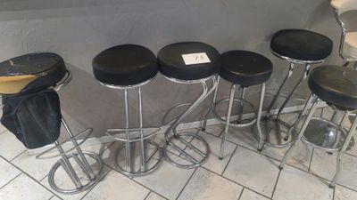 several stools are lined up against a wall in a restaurant