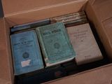 de nombreux livres dans une boîte en carton posée sur une table