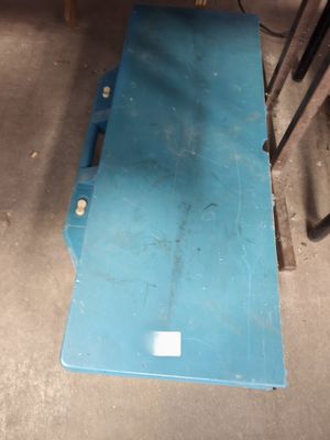 un morceau de métal bleu posé par terre dans le garage