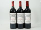 three bottles of red wine are lined up on a white surface