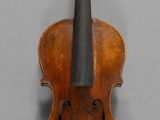 un gros plan sur un violon accroché au mur