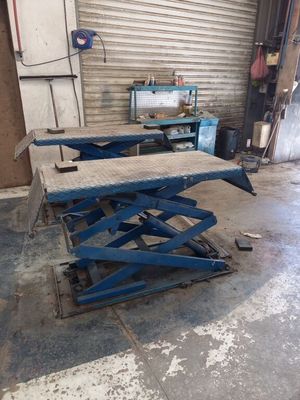 a close up of two scissor tables in a garage