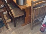 a wooden table with a pot on it next to two chairs