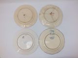 four plates with designs on them sitting on a white surface