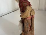 a figurine of a woman with a hat and scarf