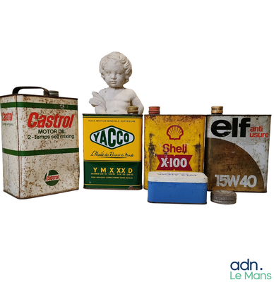 a statue of a child sitting next to some old oil cans