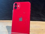 a red iphone sitting on top of a wooden table next to a black wall