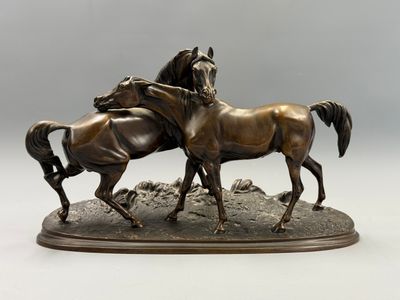 sculpture en bronze représentant deux chevaux sur un rocher, sur fond blanc