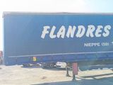 a large blue truck that is parked in a lot