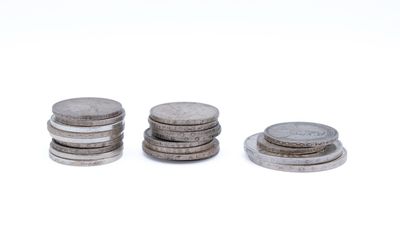 three stacks of coins sitting on top of each other on a white surface