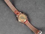 a close up of a wrist watch with a brown leather band