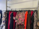 a lot of clothes hanging on a rack in a store
