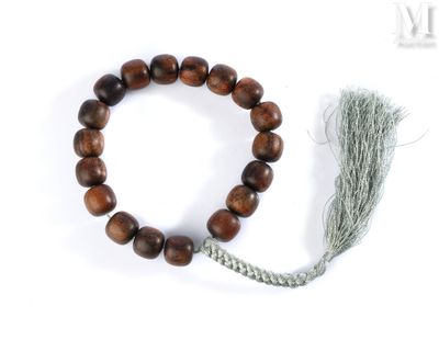 un gros plan d'un bracelet orné d'un pompon, posé sur une surface blanche