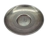 a silver plate with a design on it on a white background