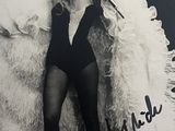 photographie en noir et blanc d'une femme vêtue d'un body et tenant un micro