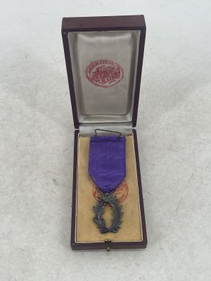 a purple ribbon in a wooden box with a purple ribbon on it