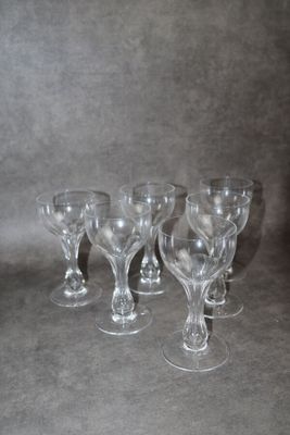 quatre verres à vin vides sont alignés sur une surface grise