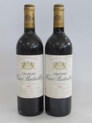 two bottles of red wine sitting next to each other on a table