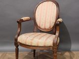 a wooden chair with a striped upholstered back and arms
