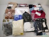 de nombreux vêtements de toutes sortes dans le sac posé sur la table