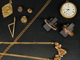 de nombreux bijoux en or posés sur une table noire