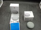 un carton contenant des enceintes Google Home Mini et un carton contenant des enceintes Google Home Mini