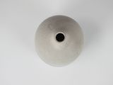 a white vase with a black hole in the middle of it