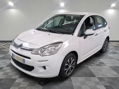 la petite voiture blanche est garée sur un carrelage à carreaux