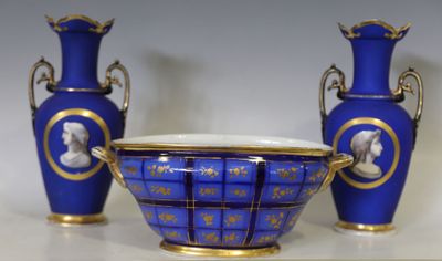 trois vases bleus posés sur une table aux bordures dorées