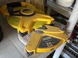 yellow and black tools are sitting on a shelf in a garage