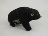 a small black bear and a small brown bear on a white surface