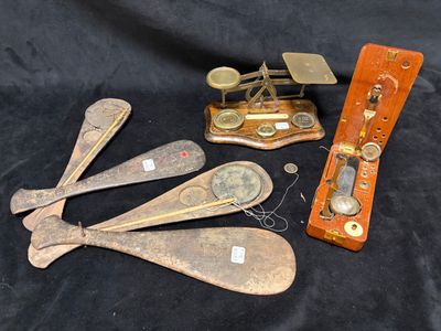 five antique wooden spoons and a scale on a black cloth