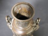 a silver vase that is sitting on a table