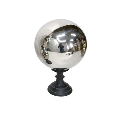 une boule argentée posée sur un socle noir, sur fond blanc