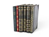 trois livres sont empilés sur une surface blanche