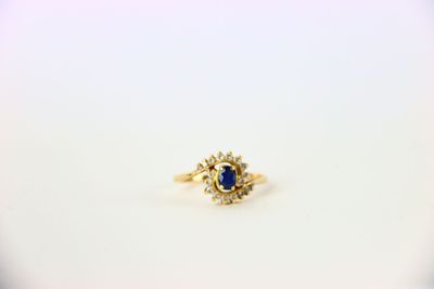 une bague en or jaune sertie d'un saphir entouré de diamants